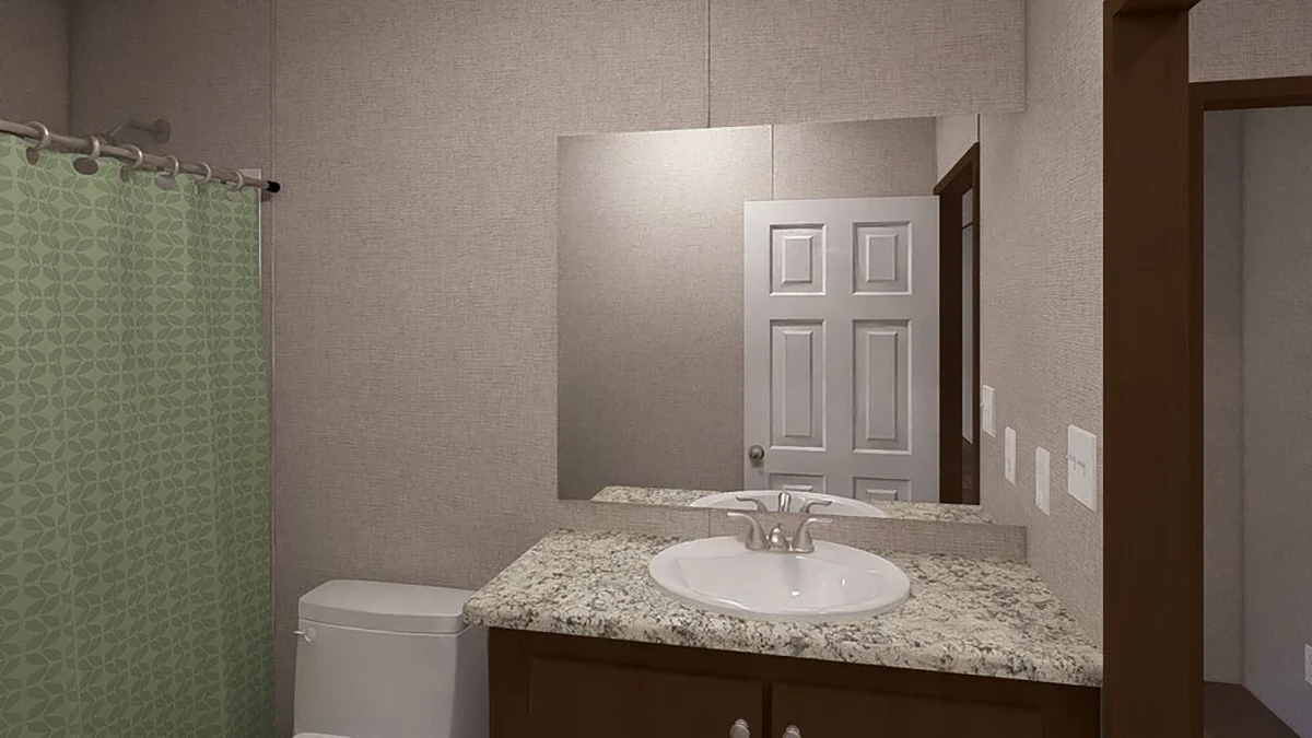 A bathroom with a white sink on a granite countertop, a toilet, a green shower curtain, and a wall mirror reflecting a closed white door.