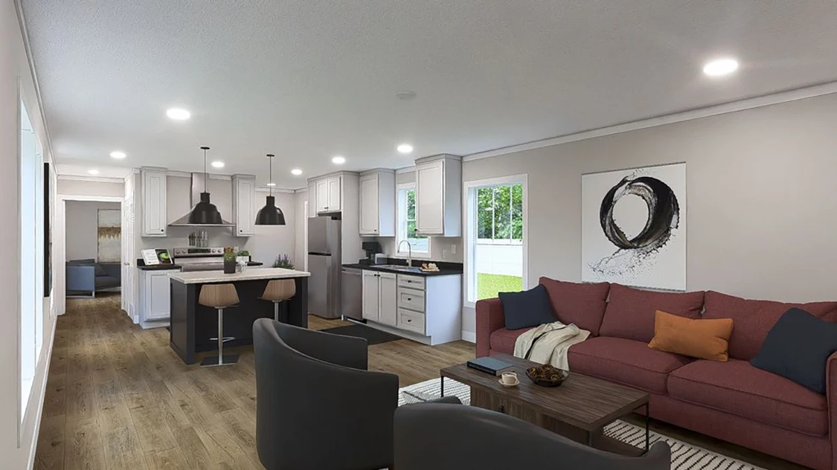 Open-plan living room and kitchen with wood flooring, modern furniture, a red sofa, two dark armchairs, and pendant lights over a kitchen island. Large windows provide natural light.