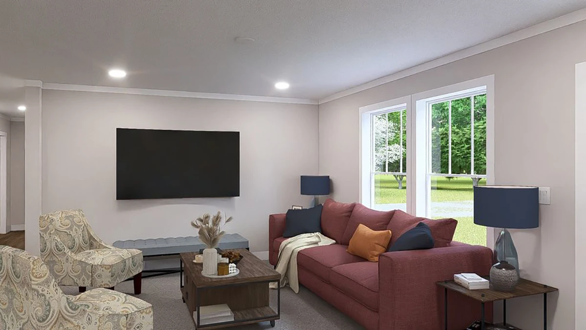 A modern living room with a red sofa, two patterned armchairs, a coffee table, two blue lamps, a large wall-mounted TV, and windows overlooking a green yard.