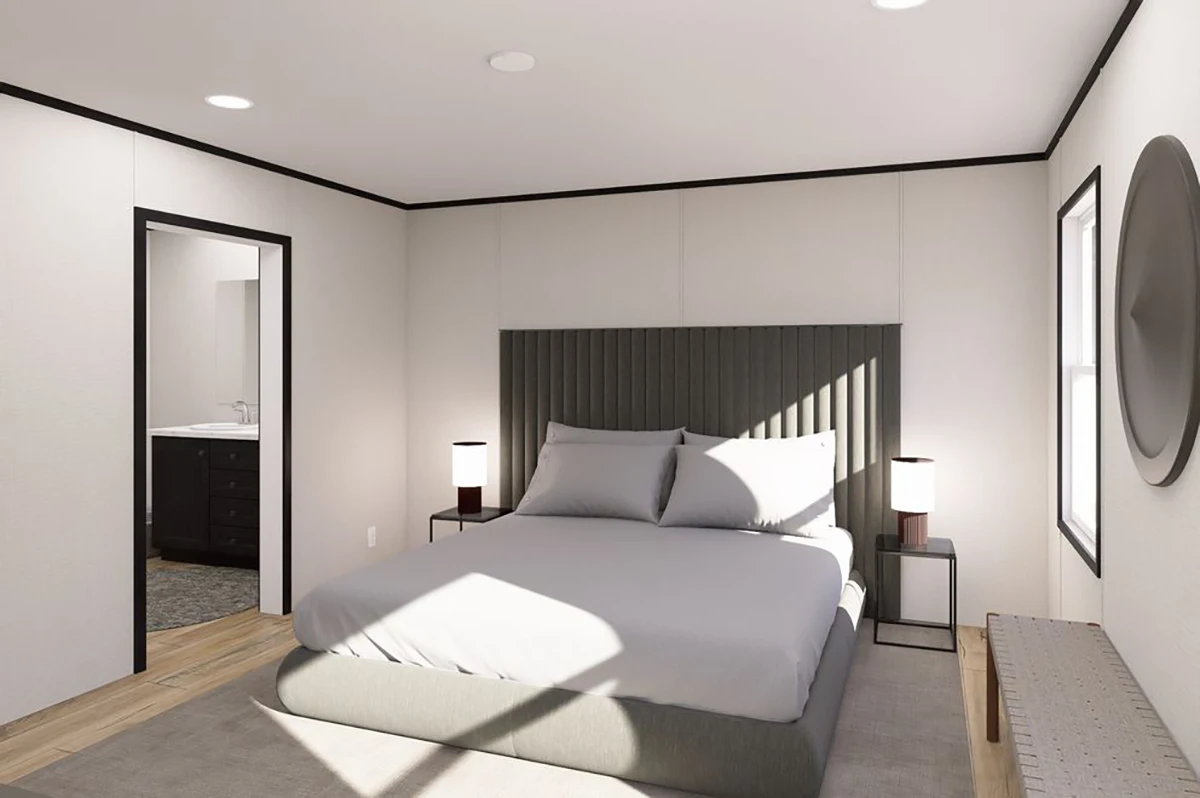 38b87adf-e8b8-457c-9b85-709f7049a16a A modern bedroom with a gray upholstered bed, white bedding, two bedside tables with lamps, a bench, and an open door leading to a bathroom.