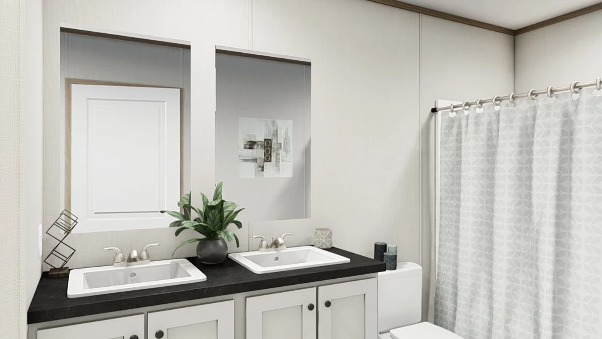 38d27e3a-355b-4cb6-a1f3-050f6dbe20b9 Modern bathroom with double sinks, a potted plant on the counter, a toilet, wall art, and a shower with a patterned curtain.