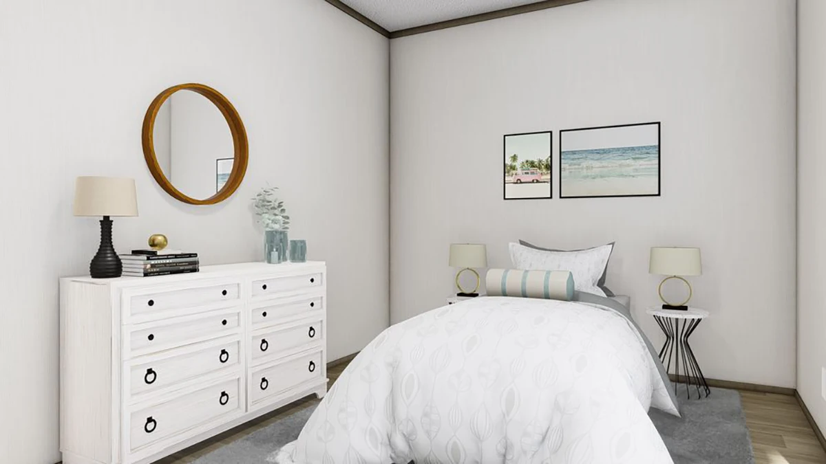 A neatly made bed with white bedding faces a white dresser with a round mirror, two framed pictures, and two bedside tables with lamps in a minimalist bedroom.