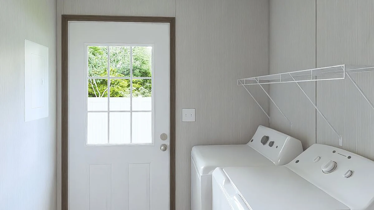 A laundry room with a washer and dryer, a wire shelf above them, and a door with a window leading outside.