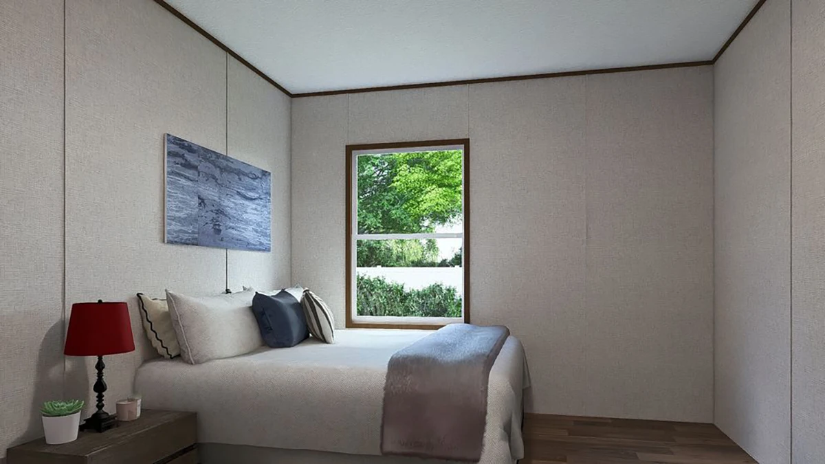 46bbcc36-2f87-428d-881d-846c2083c1a4 A small bedroom with a bed, gray bedding, a red lamp on a nightstand, a plant, a window with a view of greenery, and a painting on the wall.