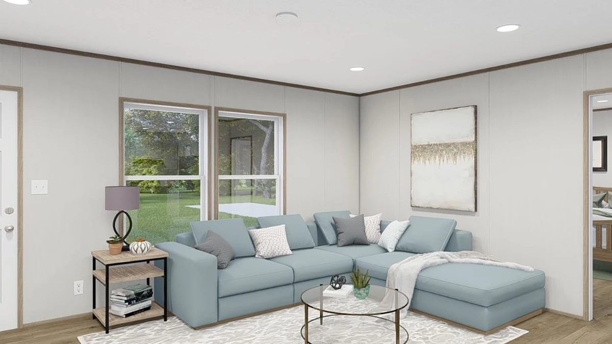 Modern living room with a light blue sectional sofa, glass coffee table, side table with lamp, large window, wall art, and neutral decor.