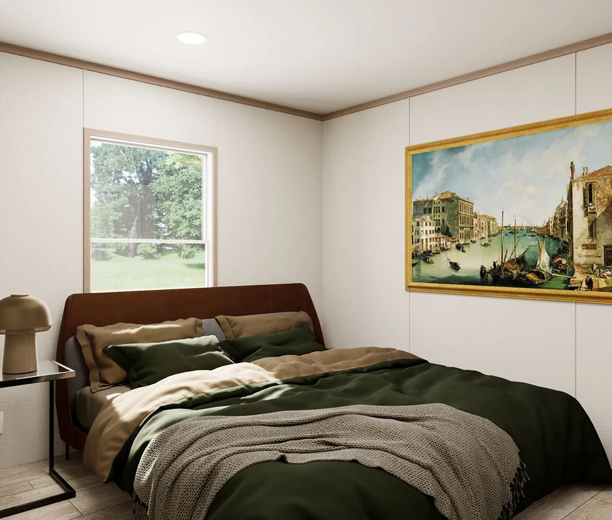 A neatly made bed with green bedding, a brown headboard, a beige throw blanket, a side table with a lamp, a window, and a framed painting of a canal scene on the wall.