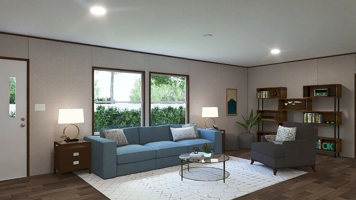 A modern living room with a blue sofa, gray armchair, two lamps, shelves with books, a round coffee table, and large windows letting in natural light.