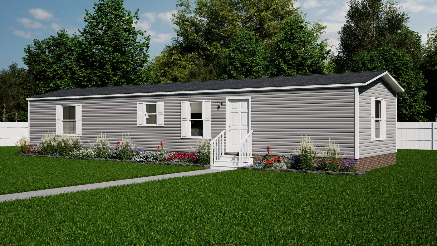 A single-story, gray manufactured home with white trim and a small front porch, surrounded by grass, landscaping, and a white fence.