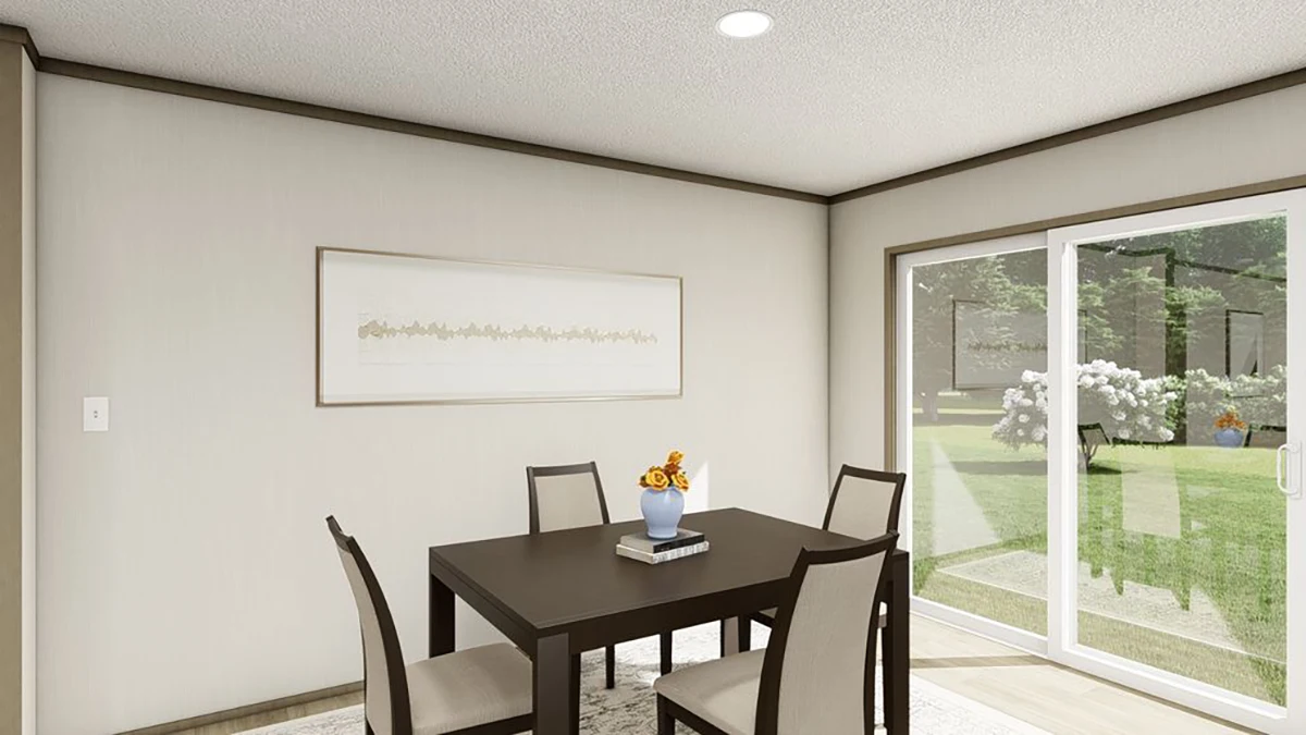A dining room with a square table, four chairs, a vase with flowers, wall art, and large sliding glass doors showing a view of a garden.