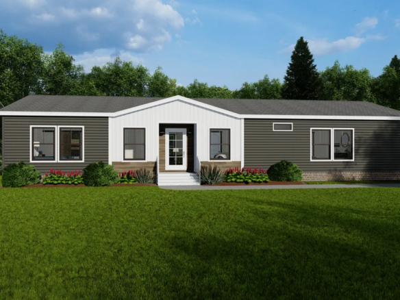 A single-story manufactured home with dark siding, a white entrance, and a well-kept lawn, set against trees and a partly cloudy sky.