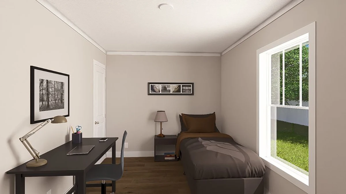 A small bedroom with a single bed, desk, chair, lamp, and framed pictures on light-colored walls, with sunlight coming through a window.