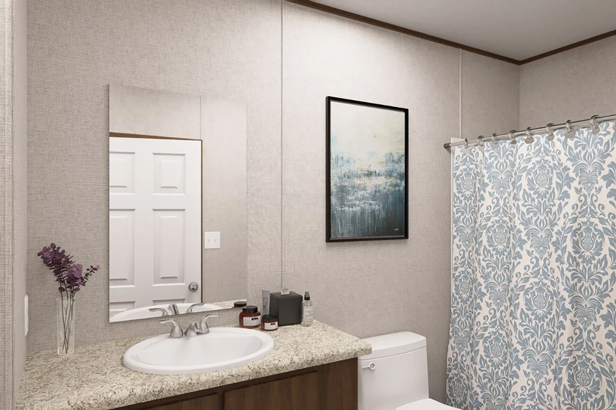 5b925edc-534a-4ce6-ac2e-85cbe1c190dd A bathroom with a sink, mirror, and countertop, a toilet, a shower with a patterned curtain, and a framed abstract painting on the wall.