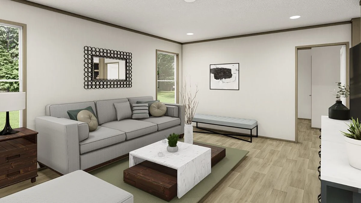 Modern living room with a gray sofa, wooden tables, a wall mirror, abstract art, and large windows letting in natural light.