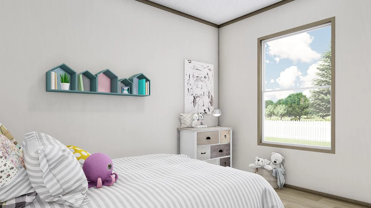 A neatly made bed with striped bedding, plush toys, a dresser with drawers, wall art, and a window showing trees outside in a light-colored bedroom.