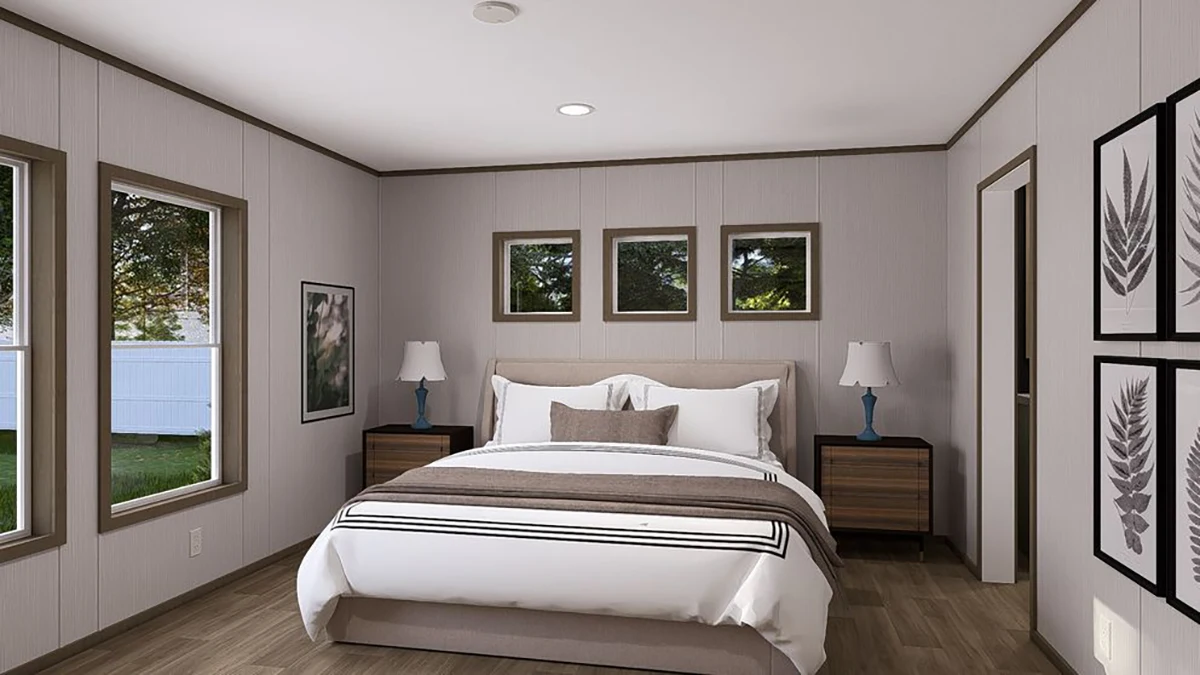A modern bedroom with a double bed, two nightstands with lamps, three windows above the bed, and framed artwork on the walls.