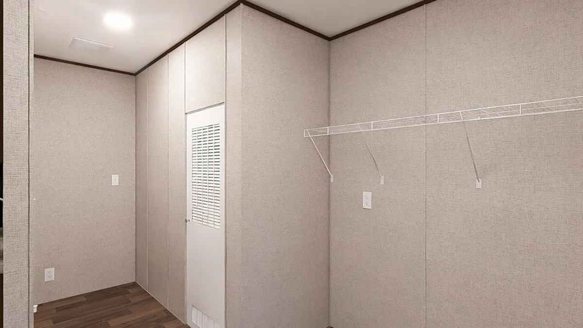A minimalist room with beige walls, a vented door, a white wire shelf, and dark wood flooring under recessed lighting.