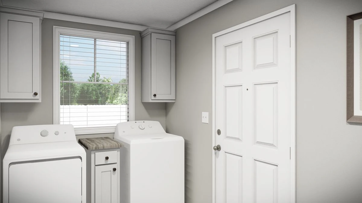 62814144-4ea4-4782-8fab-926a8ecd2a13 A laundry room with a washing machine, dryer, small cabinet, large window, upper cabinets, and a white door.