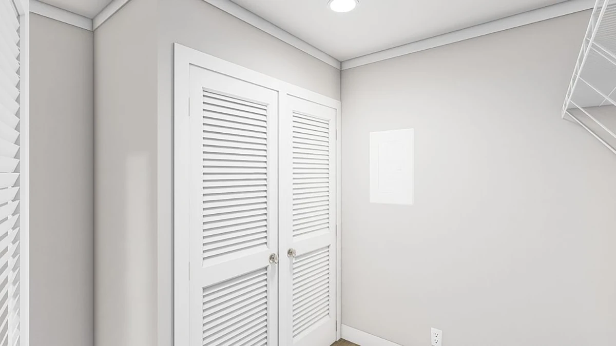 65876058-75e9-407f-bd84-deace4fdfddc A small laundry room with beige walls, white trim, a double door with louvered panels, a ceiling light, and a wire shelf on the right wall.