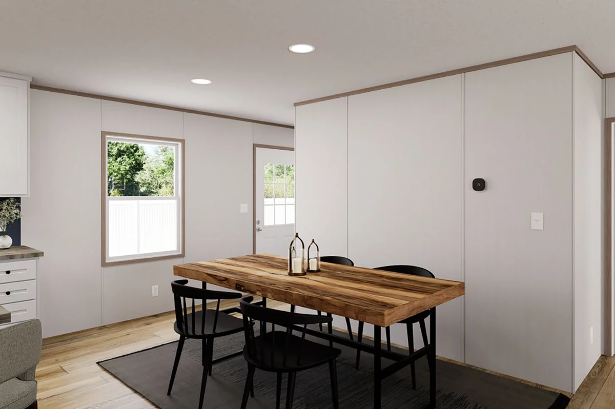 67d83696-8fd1-484d-97a1-562e845de05a A minimalist dining area with a wooden table, four black chairs, a dark rug, and white walls near a window and door.