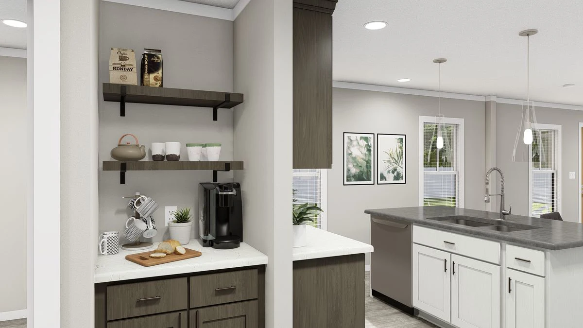 A kitchen coffee nook with shelves holding cups and decor, a coffee maker, and a small counter next to a modern kitchen with an island and sink.