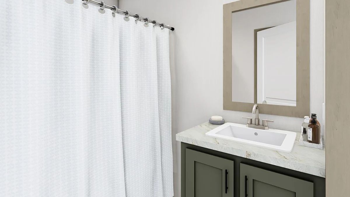 A bathroom with a white shower curtain, a rectangular mirror above a sink with a marble countertop, and green cabinets below. Soap and a bottle are placed on the counter.