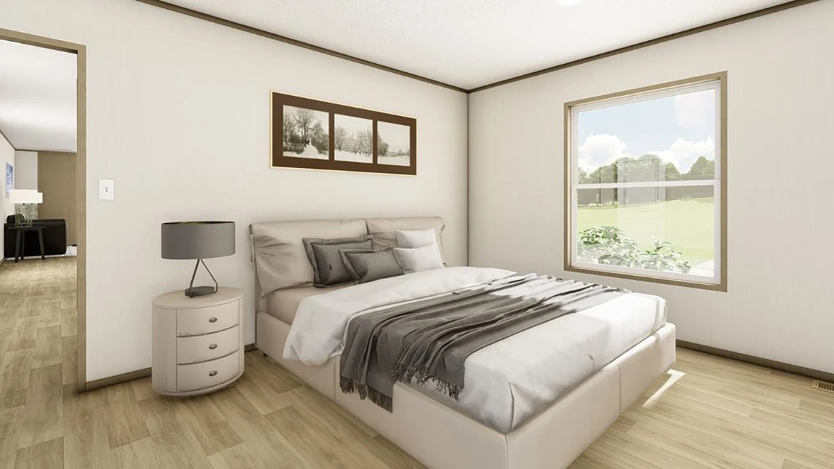 A bedroom with a bed, nightstand, lamp, and a framed picture on the wall, next to a window.