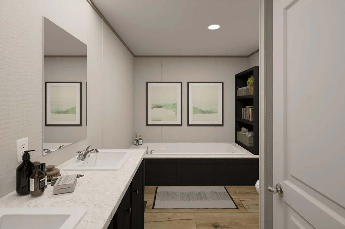 6ffcc066-5515-42b0-8586-42a9b1719ef6 Modern bathroom with a marble countertop, white sink, built-in bathtub, black cabinets, two framed pictures on the wall, and a bookshelf next to the tub.