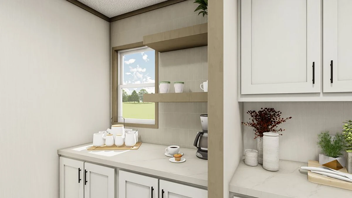 A modern kitchen corner with light cabinets, a coffee maker, cups, jars, and plants on a marble countertop near a window with a view of a grassy field.