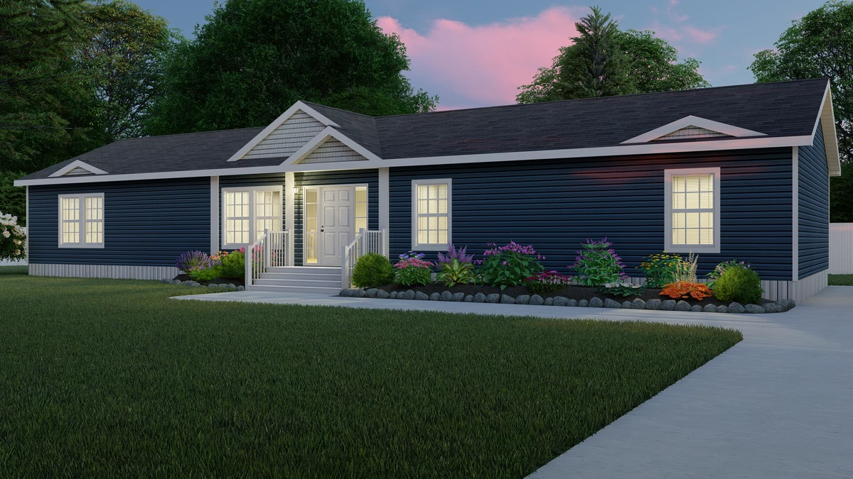 Single-story house with dark blue siding, white trim, front steps, and lit windows, surrounded by a garden and lawn at dusk.