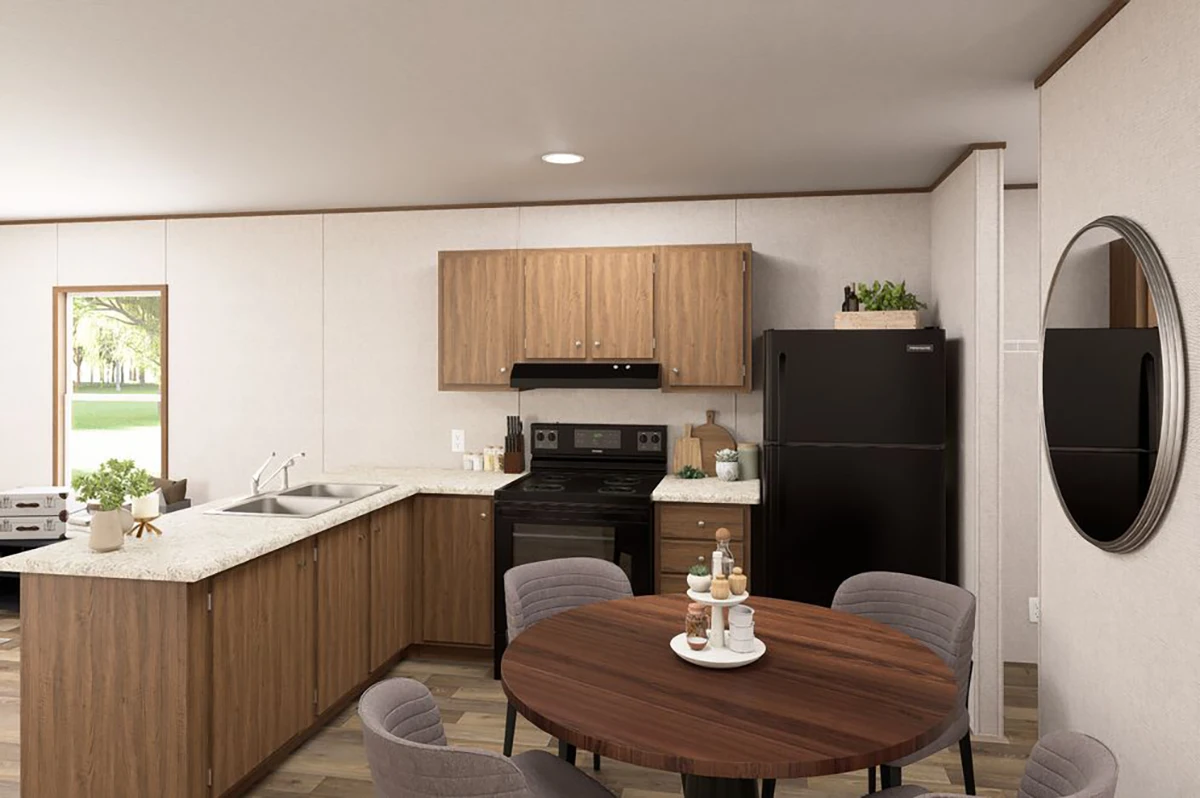 79270da1-1cc9-4abb-af35-120a37412e07 Modern kitchen with wood cabinets, black appliances, round dining table with four chairs, decorative items, and a round wall mirror.