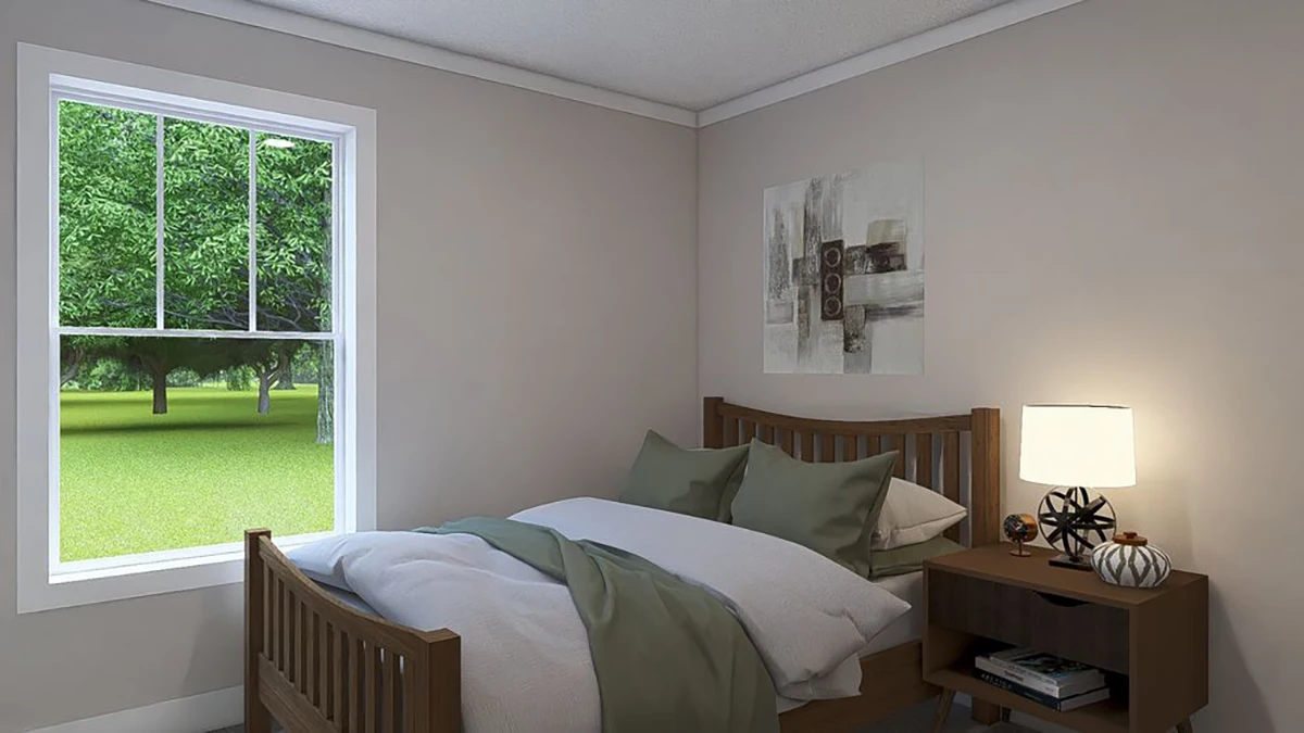 7b1d4721-6622-4728-b931-effbb1a3ce0e A neatly made bed with green sheets sits beside a wooden nightstand with a lamp and decor items in a small bedroom with a window showing trees outside.