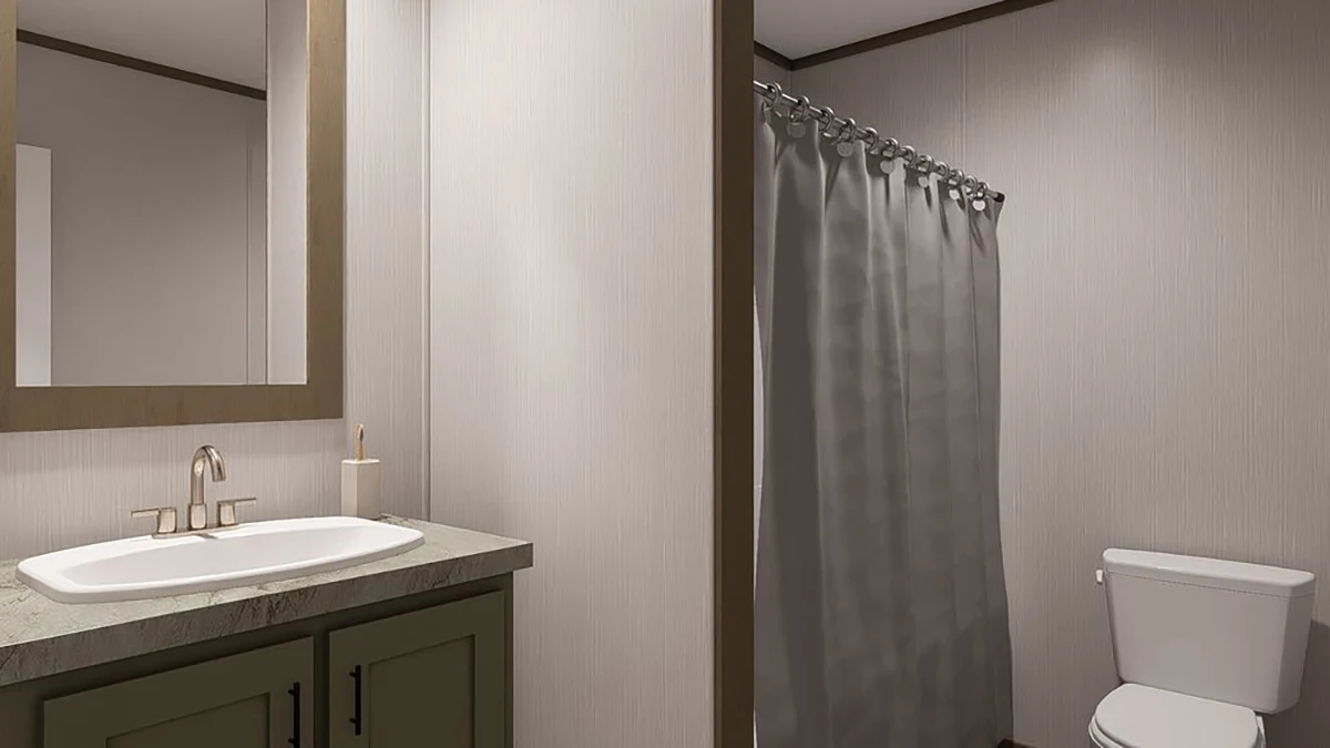 A bathroom with a sink and mirror on the left, a toilet on the right, and a shower with a closed gray curtain in the background.