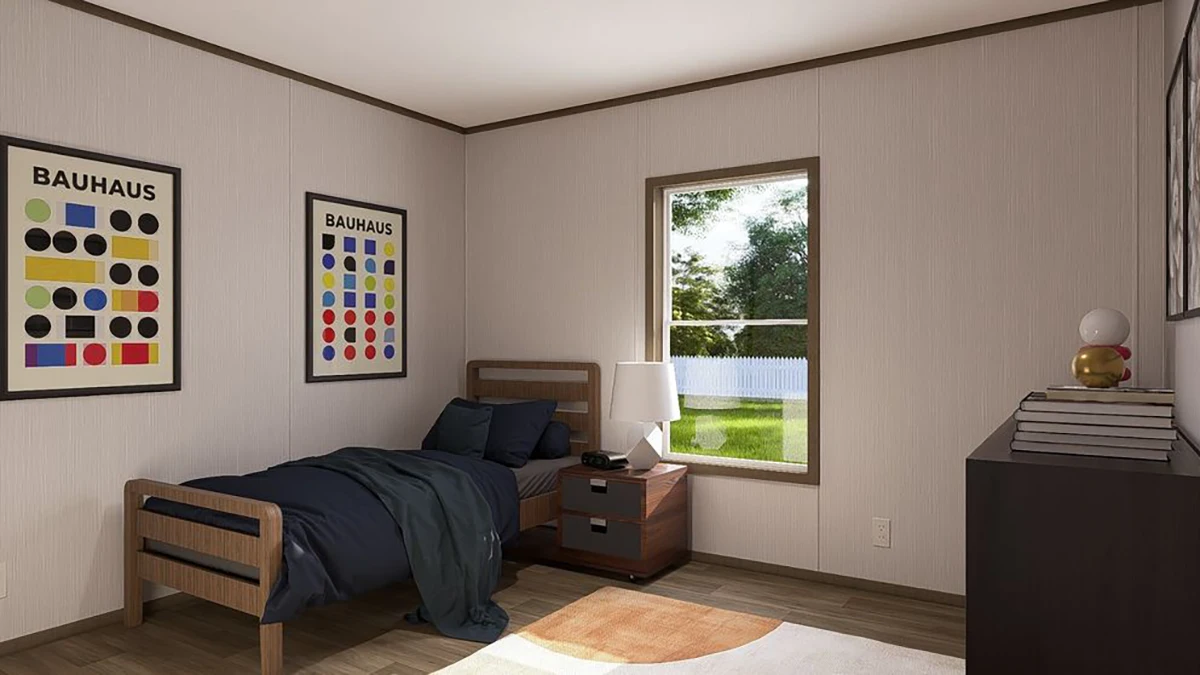 A minimalist bedroom with a single bed, dark bedding, a nightstand with a lamp, dresser, and two Bauhaus posters on the wall. Sunlight streams through a window.