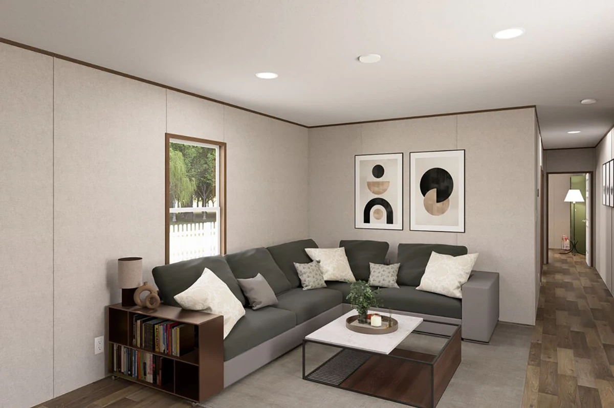 8d42c096-4868-4132-9664-18699a8ad9d7 Modern living room with a sectional sofa, coffee table, bookshelf, and abstract art on the wall; wood flooring and a window showing a fenced yard.