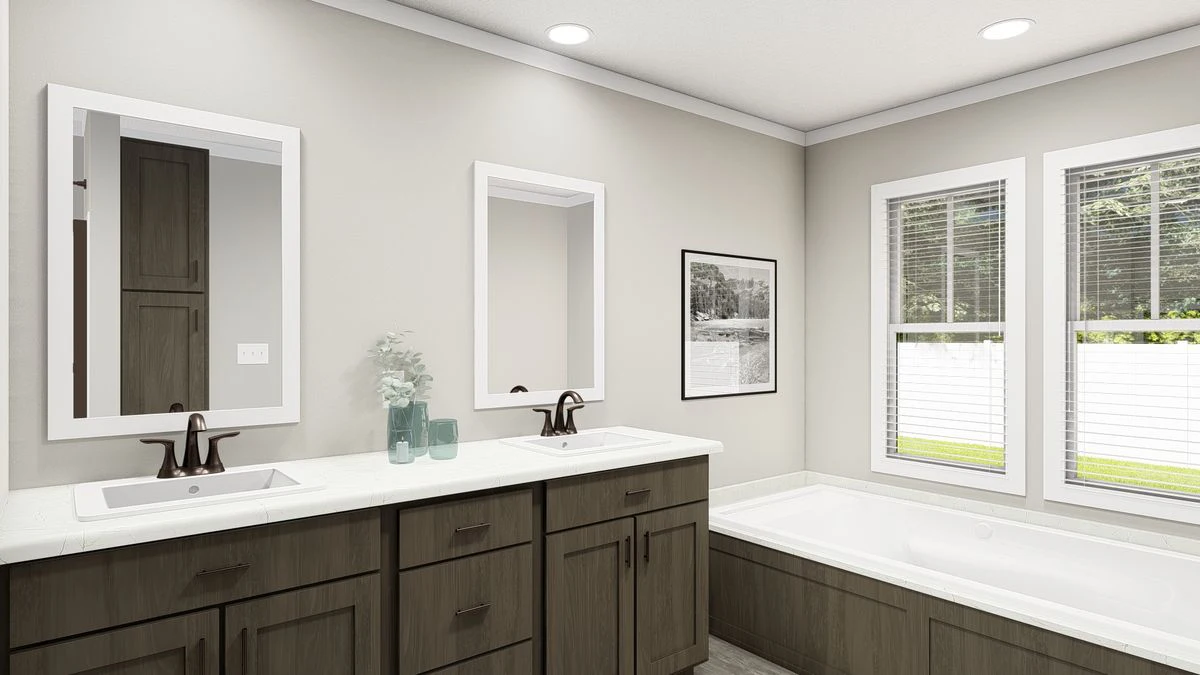 Modern bathroom with double sinks, dark wood cabinets, a large bathtub, two mirrors, a framed photo on the wall, and two windows letting in natural light.