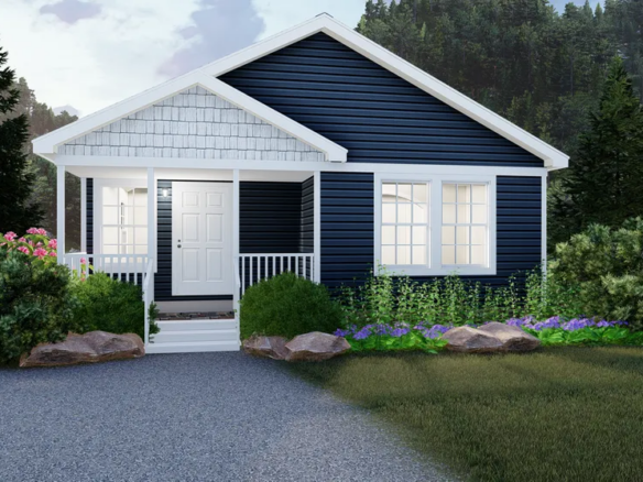 Single-story house with dark blue siding, white trim, a small front porch, and surrounding landscaping including bushes, flowers, and rocks. Trees and hills are in the background.