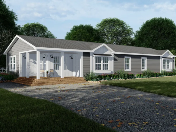 Single-story gray modular home with white trim, a covered front porch, multiple windows, and a gravel driveway, surrounded by grass and trees.
