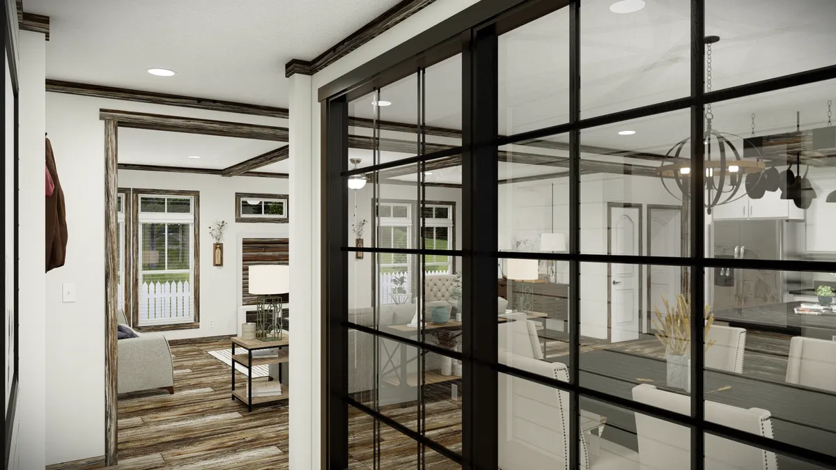 Open-concept living and dining area with glass-panel sliding doors, wood accents, and modern furnishings, featuring large windows and a view into the kitchen.