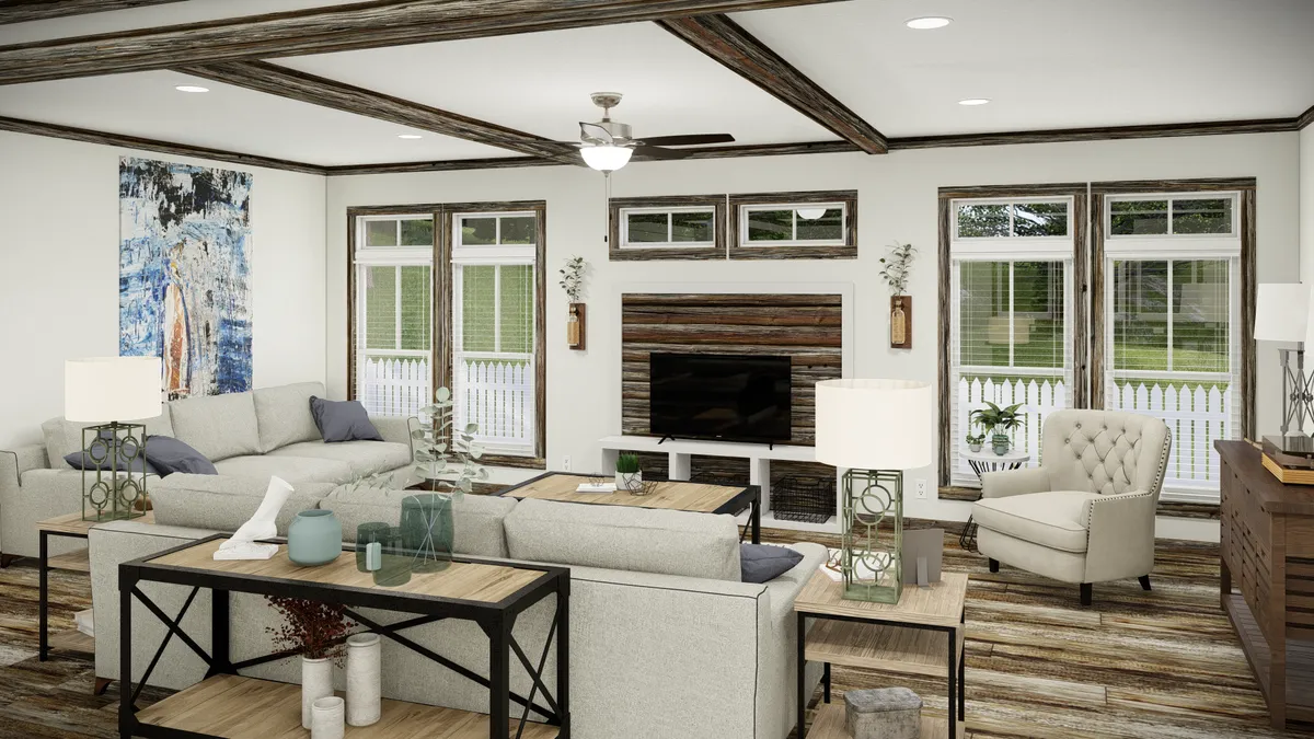 Modern living room with neutral-toned furniture, wooden accents, large windows, a ceiling fan, and a TV centered on a wood-paneled wall.