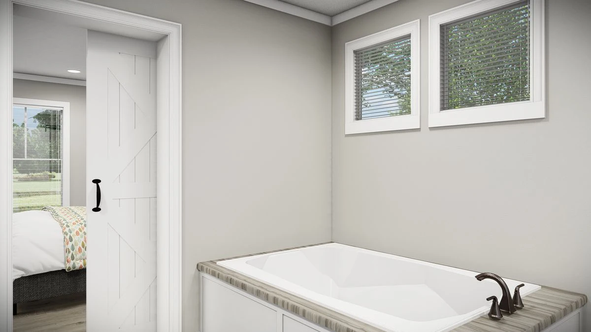 a18b479e-e3c0-47ea-b98a-d79521e9eb12 A modern bathroom with a white bathtub, two small windows with blinds, and a sliding barn door leading to a bedroom.