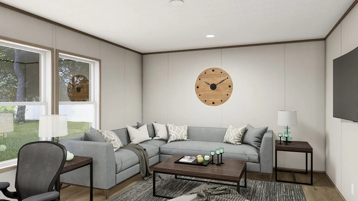 a1b8ee49-7154-47f6-a81b-11e1484a58e4 Modern living room with a gray sectional sofa, wooden coffee table, two lamps, a large wall clock, and a flat-screen TV. Sunlight comes through two windows.