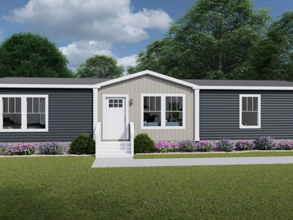 A modern single-story manufactured home with dark gray siding, white trim, front steps, and landscaped shrubs and flowers, set against a backdrop of trees and cloudy sky.
