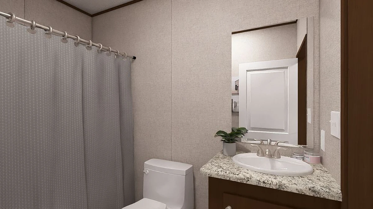 a2d91173-36b8-4184-ac4b-596129b05ce7 A small bathroom with a toilet, a sink with a granite countertop, a mirror, a potted plant, and a shower with a gray curtain.