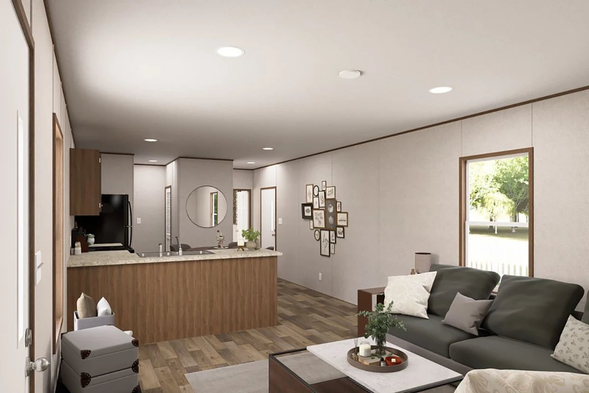 a408d5aa-b539-4c28-9eee-b73567df9955 Open-plan living area with a modern kitchen, wooden cabinets, granite countertops, and a seating area featuring a dark sofa and wall art, with large windows providing natural light.