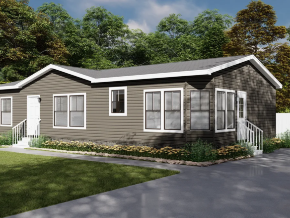 A single-story, dark brown manufactured home with white trim, multiple windows, and two small sets of steps, set on a grassy lot with a paved driveway and surrounded by trees.