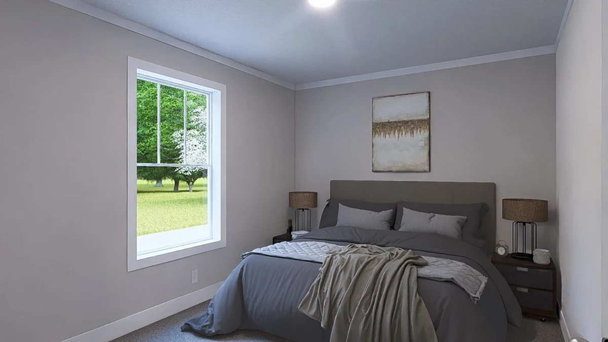 A neatly made bed with gray bedding and a blanket sits against a wall in a simple bedroom with a window, two nightstands, lamps, and a framed picture above the bed.