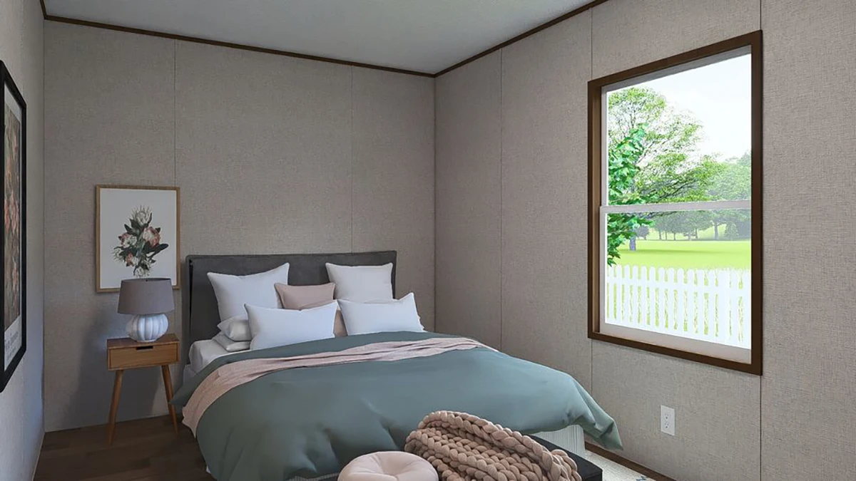 aee838b1-8b2e-4d74-8050-7d084f571049 A small bedroom with a neatly made bed, nightstand with a lamp, framed artwork on the wall, and a window overlooking a green yard with a white fence.