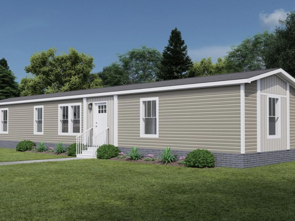 A beige single-story manufactured home with white trim and a small front porch sits on a grassy lawn, surrounded by trees and a white fence.