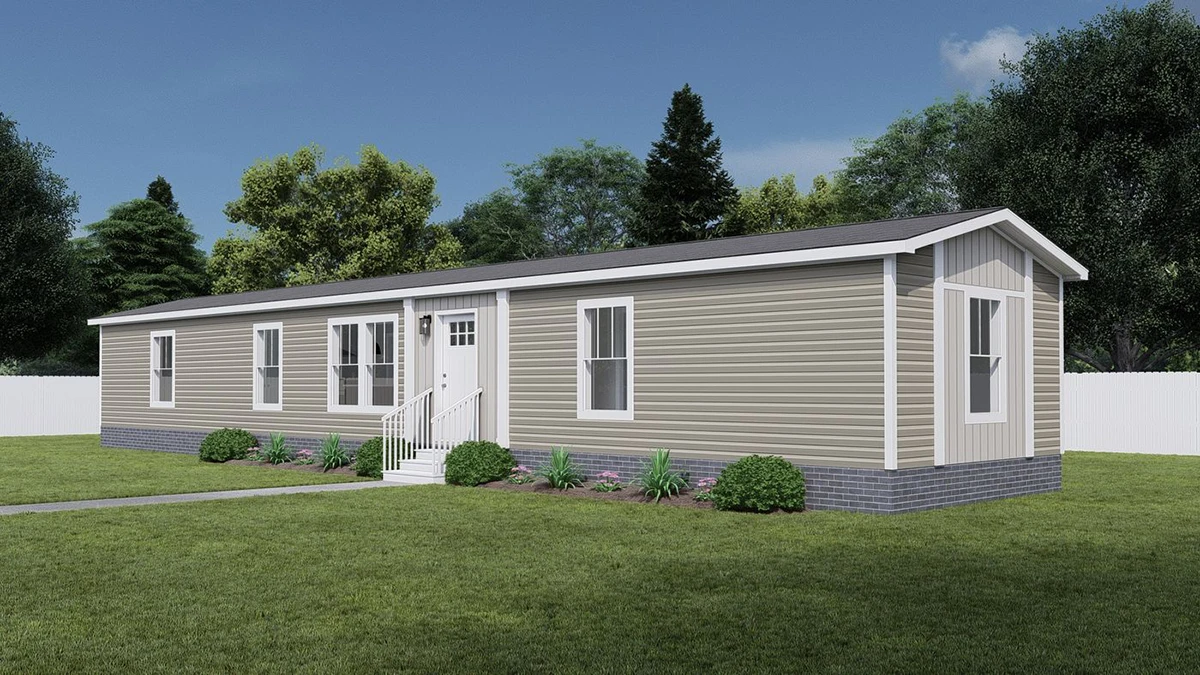 A beige single-story manufactured home with white trim and a small front porch sits on a grassy lawn, surrounded by trees and a white fence.