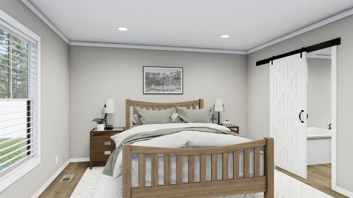 A modern bedroom with a wooden bed, two nightstands, lamps, a framed picture above the bed, and a sliding barn door leading to a bathroom.